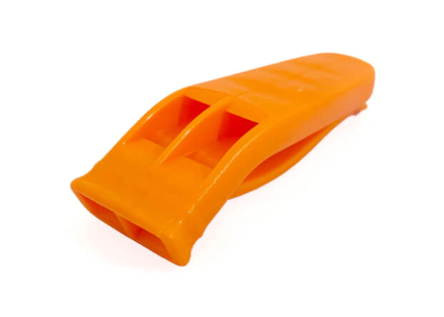 Scuba diving safety whistle attached to a BCD inflator hose